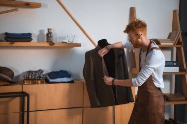 genç erkek moda tasarımcısı önlük ve elbise manken Atölyesi'nde seyir gözlük