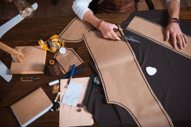 erkek moda tasarımcısı dikiş patterns, araçları ve kumaş işyerinde çalışma kırpılmış atış  
