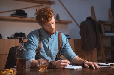 Not alma ve işyerinde viski içme genç moda tasarımcısı