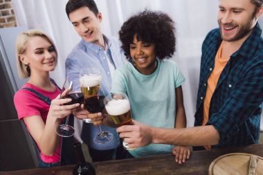 çok ırklı arkadaş ile şarap ve bira bardakları tokuşturup havai görünümü