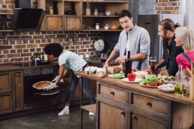 Afro-Amerikan Kız ev yapımı pizza arkadaşlarıma mutfakta getiriyor.