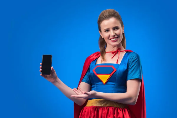Πορτρέτο Του Χαμογελαστό Γυναίκα Στο Κοστούμι Superhero Δείχνει Smartphone Κενή — Φωτογραφία Αρχείου
