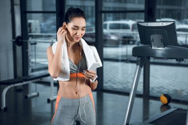 genç atletik kadın spor salonunda kulaklık ile müzik dinleme
