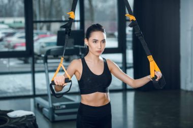 genç kadın spor salonunda direnç gruplarla çalışma dışarı yerleştirmek