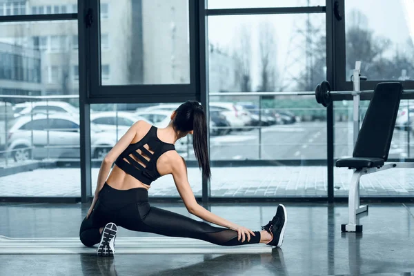 Vista Trasera Mujer Atlética Estirando Pierna Esterilla Yoga Gimnasio — Foto de Stock