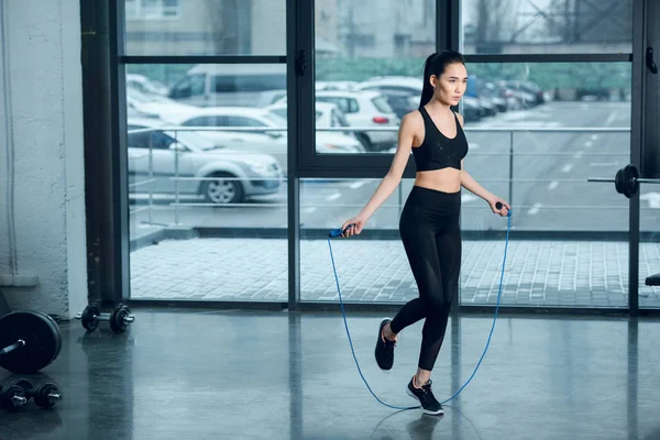 年轻的体育女子在健身房跳绳 — 图库照片