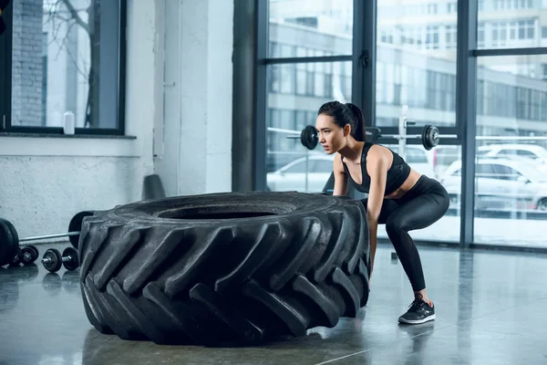 Mladá Žena Sportovní Překlápění Kola Cvičení Tělocvičně — Stock fotografie