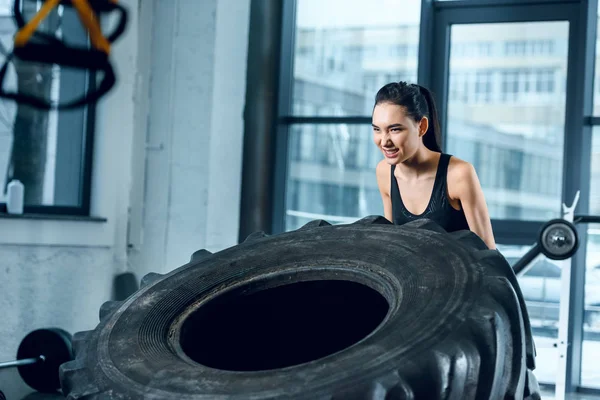 年轻强壮的女子在健身房翻转健身轮 — 图库照片