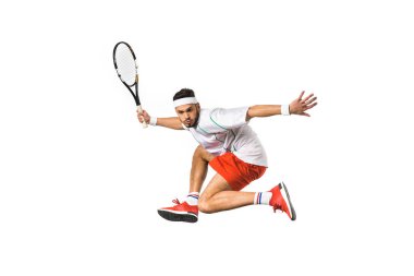 Raket tutarak ve üzerinde beyaz izole tenis oynamaya genç tenisçi