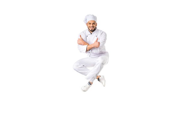 happy young male chef showing thumbs up and smiling at camera isolated on white 
