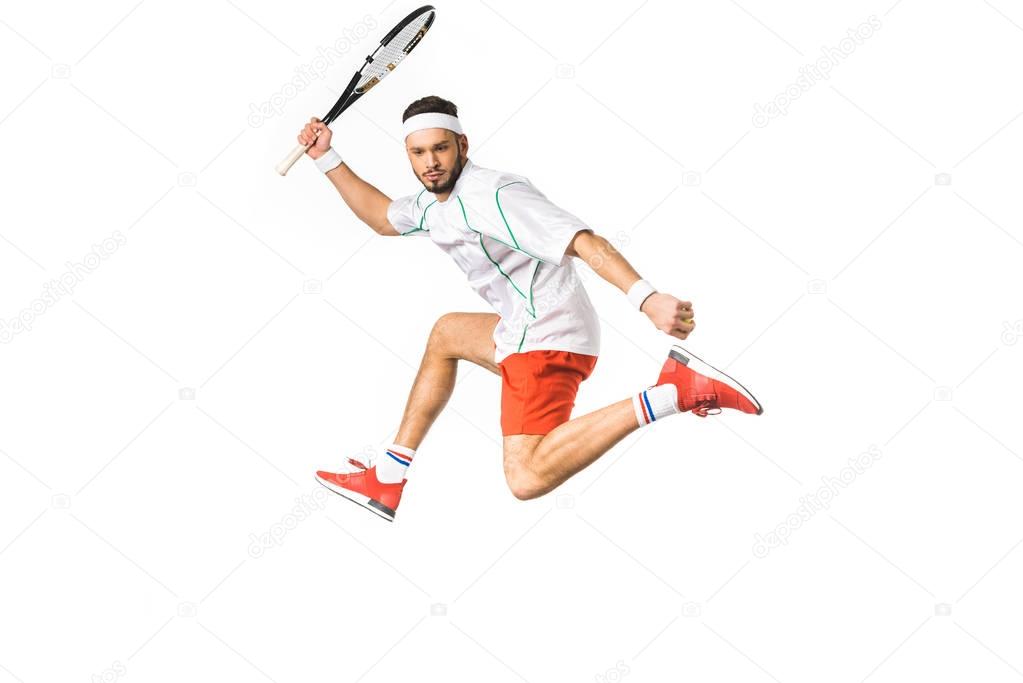 young sportsman jumping while playing tennis isolated on white