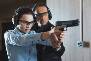 erkek eğitmen silah tutan çekici kadın müşteri yardım 
