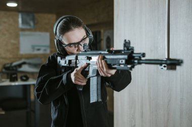 girl aiming rifle in shooting range clipart