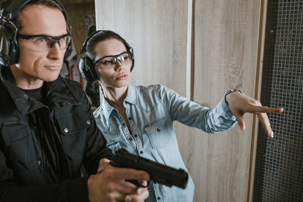 female customer pointing on something in shooting gallery