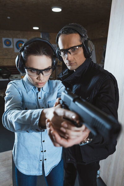 instructor helping customer holding gun