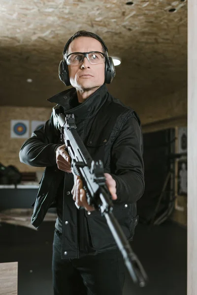 handsome man with rifle in shooting range