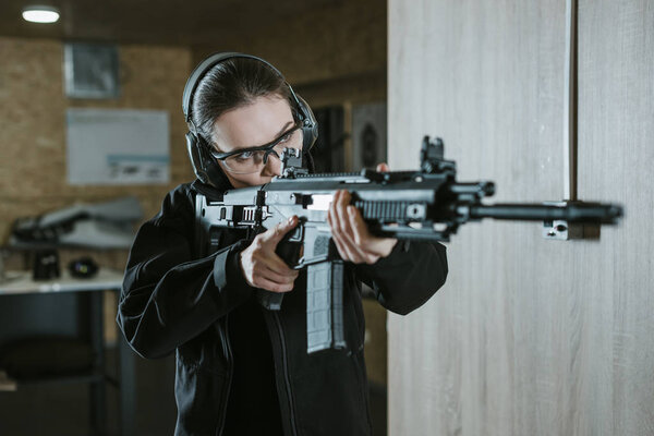 girl aiming rifle in shooting range
