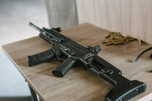 射击范围内的木桌上有子弹的黑色步枪 — 图库照片