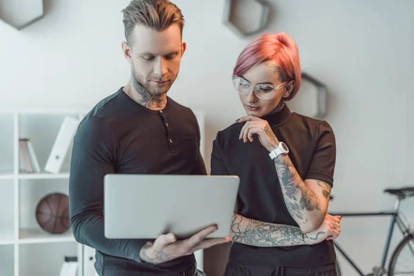 Jovens Colegas Tatuados Usando Laptop Juntos Escritório — Fotografia de Stock