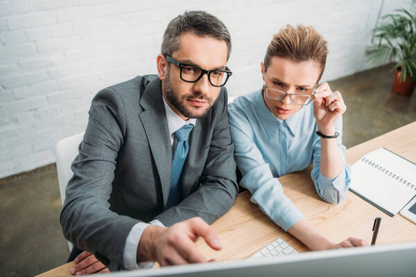 concentrated businesspeople working with computer together at modern office