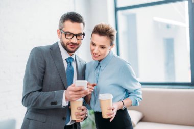 gitmek için onun Smartphone-e doğru collleague kahve yaparken gösterilen iş adamı