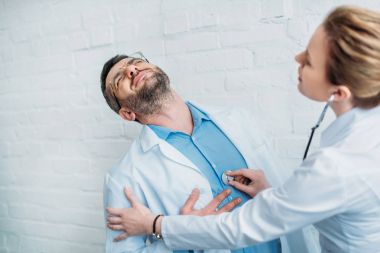 kadın doktor stetoskop ile kalp krizi geçirdi meslektaşının kalp atışı dinlerken