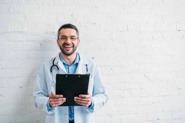 Guapo Médico Con Portapapeles Delante Pared Ladrillo Blanco — Foto de Stock