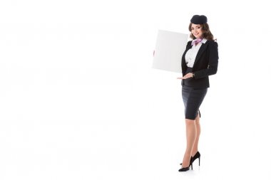 attractive stewardess holding empty board and looking at camera isolated on white clipart