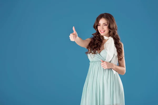 Smiling Girl Blue Dress Showing Thumb Isolated Blue — Free Stock Photo