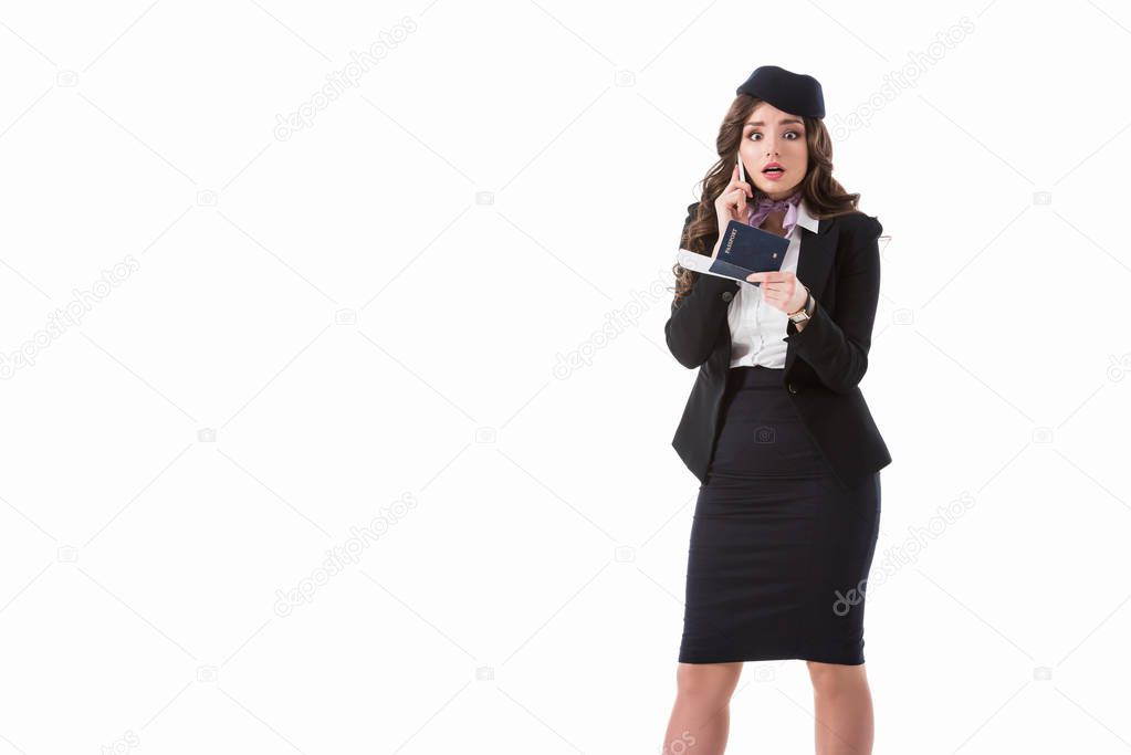 shocked stewardess talking by smartphone and holding passport isolated on white