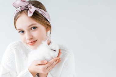 tüylü beyaz tavşan tutarak ve üzerinde beyaz izole kamera bakıyor tatlı çocuk