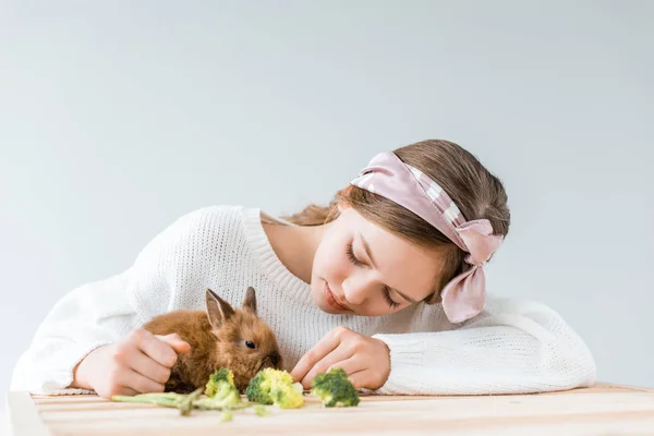 Adorable Girl Feeding Cute Furry Rabbit Broccoli Wooden Table — Stock Photo, Image