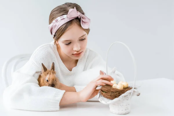 Милая Маленькая Девочка Обнимает Кролика Смотрит Корзину Пасхальными Яйцами Гнезде — стоковое фото