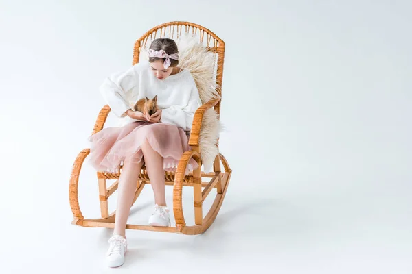 Rozkošný Dívka Drží Chlupaté Králičí Zatímco Sedí Houpací Křeslo Izolované — Stock fotografie zdarma