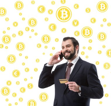 işadamı kredi kartı üzerinde beyaz izole smartphone, bitcoin ve para sembolleri konuşurken ile