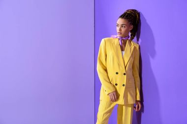 Afro-Amerikan kız trendy ultra violet zemin üzerine sarı elbiseli poz