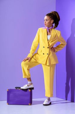 Afro-Amerikan model mor çanta trendy ultra violet zemin üzerine sarı elbiseli poz