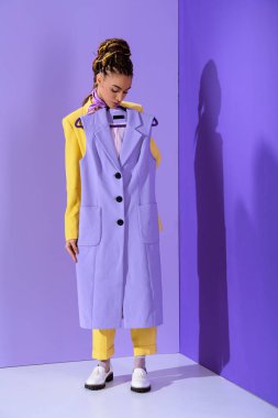 zarif Afro-Amerikan kız mor yelek, trendy ultra violet arka plan üzerinde tutan sarı elbiseli