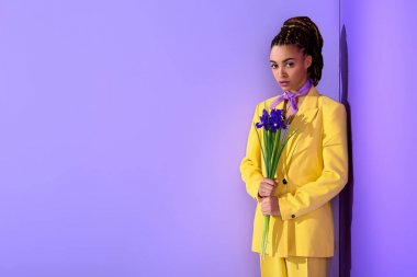 Afrikalı-Amerikalı kız ile süsen, trendy ultra violet zemin üzerine sarı elbiseli