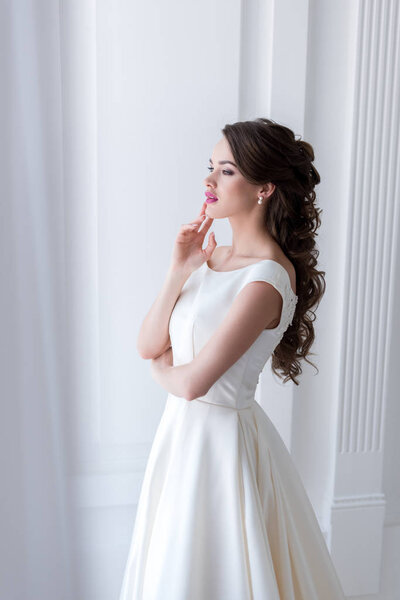 красивая мечтательная невеста в свадебном платье
