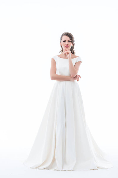 вдумчивая невеста позирует в традиционном свадебном платье, изолированные на белом
