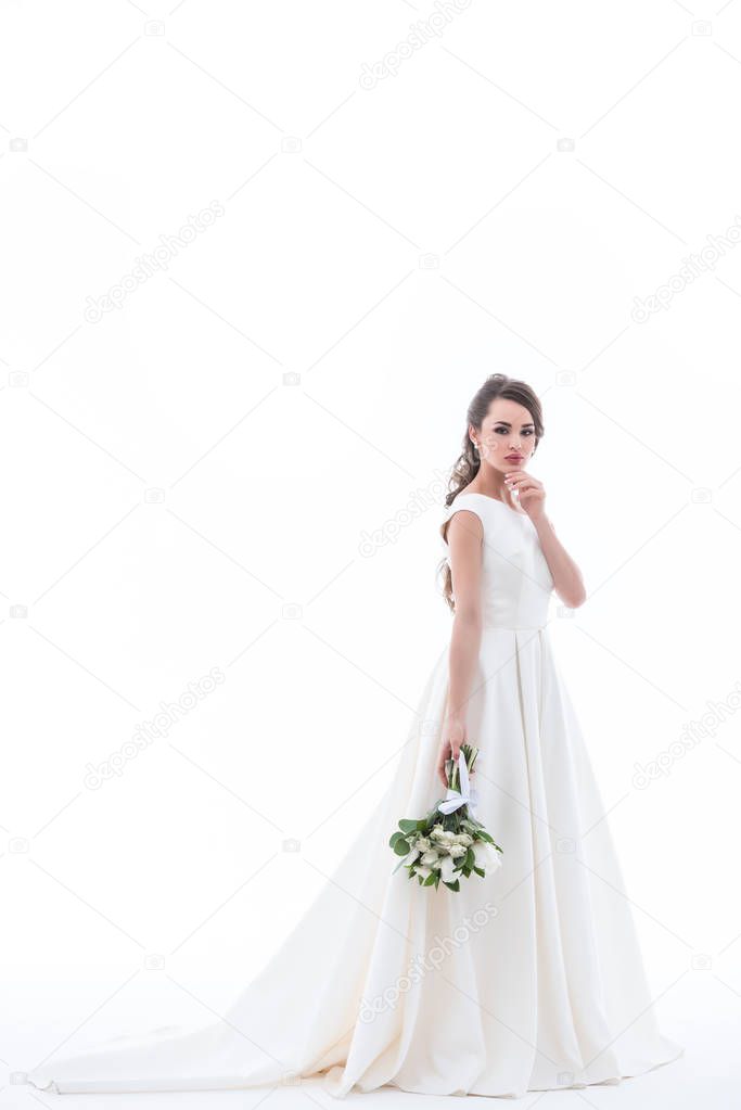 attractive bride posing in traditional white dress with wedding bouquet, isolated on white