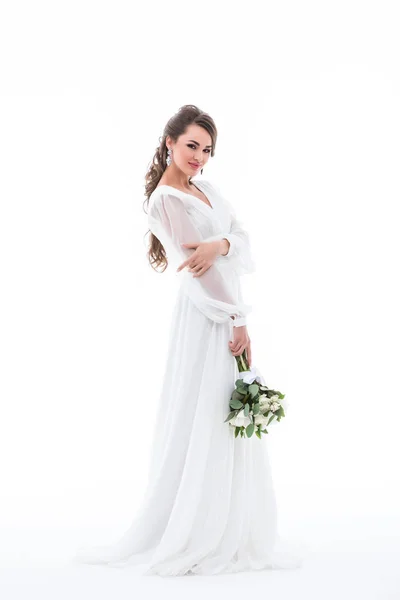 微笑的新娘摆在白色礼服与婚礼花束 孤立的白色 — 图库照片