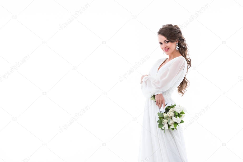 smiling bride posing in white traditional dress with wedding bouquet, isolated on white