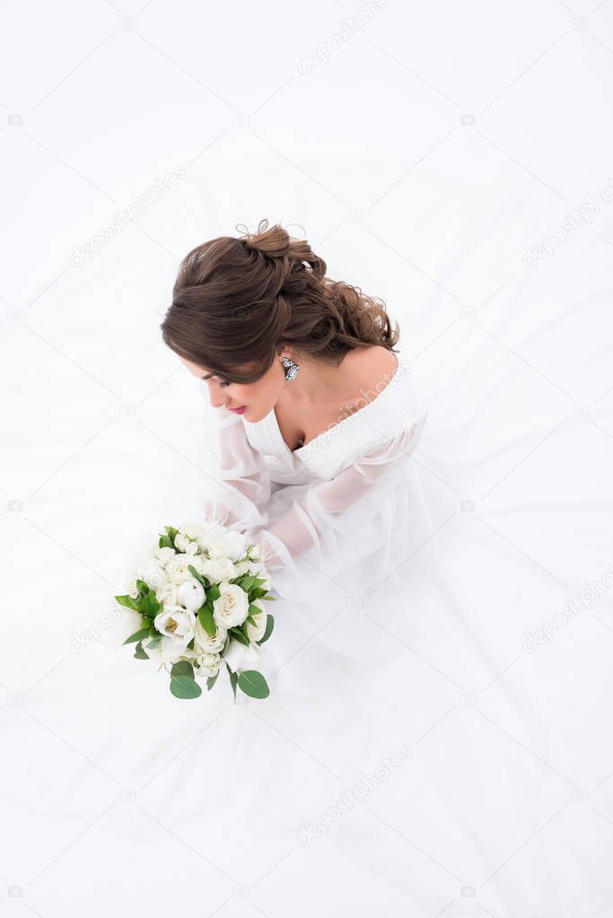 overhead view of elegant bride in traditional dress holding wedding bouquet, isolated on white