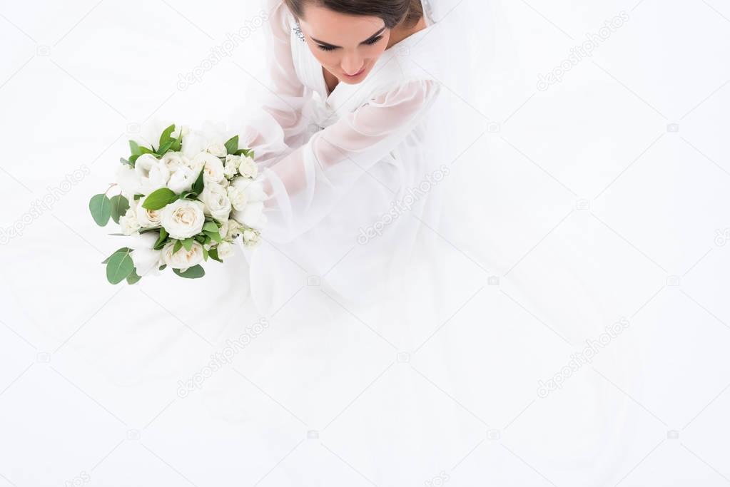 overhead view of bride in traditional dress holding wedding bouquet, isolated on white