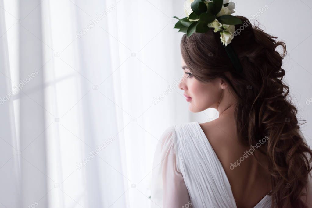 beautiful bride in traditional dress and floral wreath 