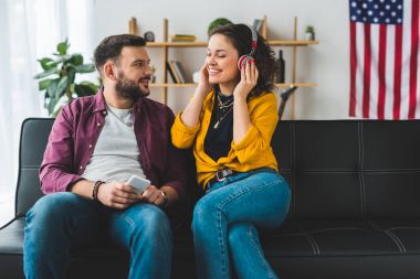 Smartphone onun kız arkadaşı müzik dinleme sırasında hadphones içinde tutan adam