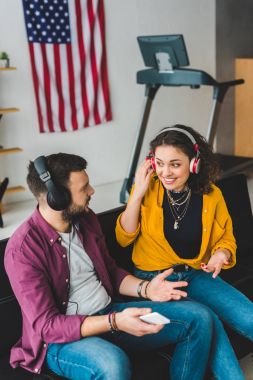 Kulaklıklar müzik dinleme ve kanepede oturan çift görünümünü