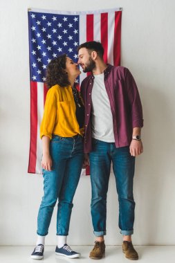 Genç çift duvar önünde Amerikan bayrağı